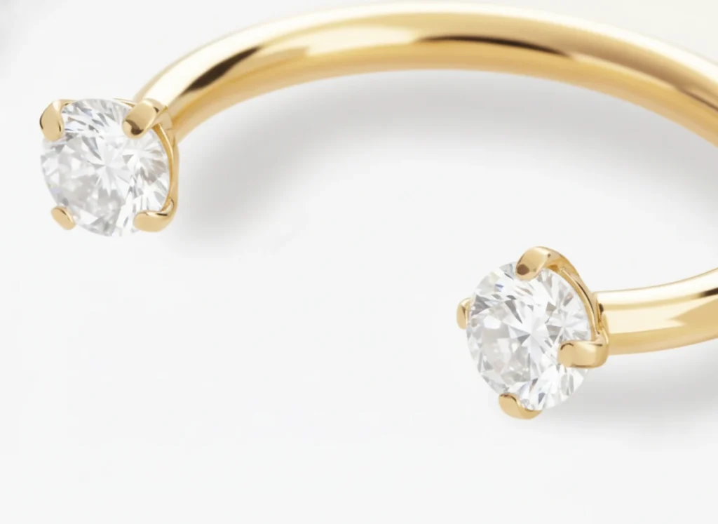 Piercing fer à cheval doré avec zircons brillants, vue en gros plan détaillée