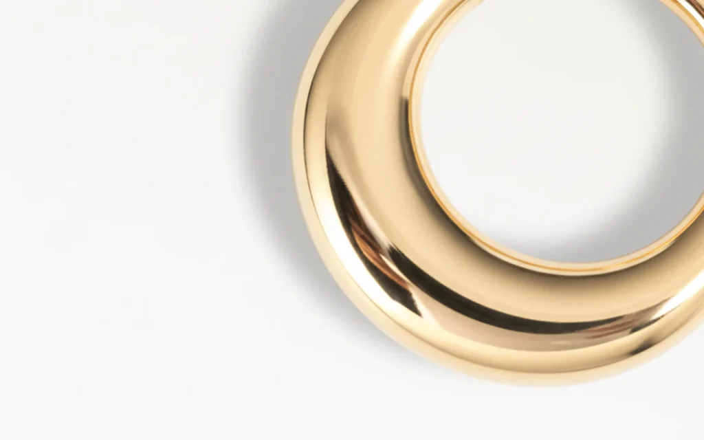 Gros plan sur anneau de piercing doré, détail du métal poli et brillant