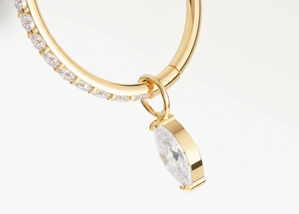 Piercing anneau doré avec pendentif goutte en zircon, vue en gros plan détaillée