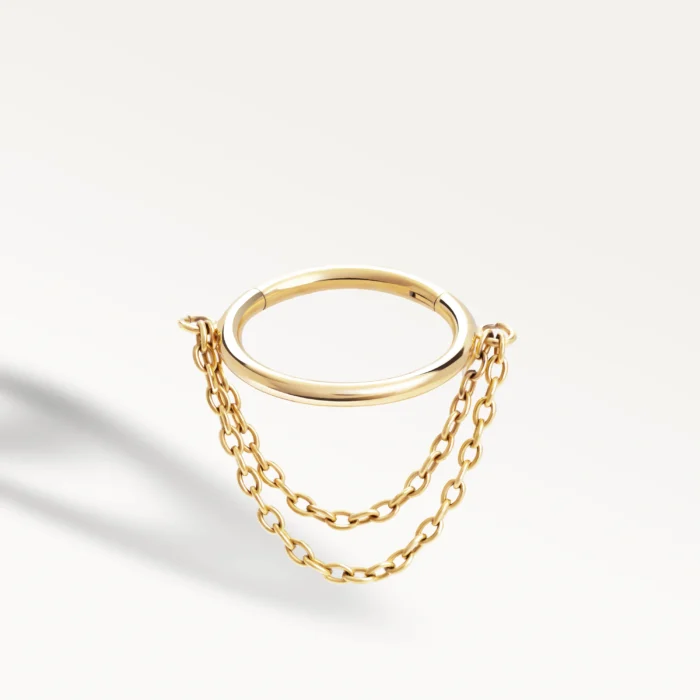 Piercing conch doré orné de deux chaînes délicates reliées à l’anneau