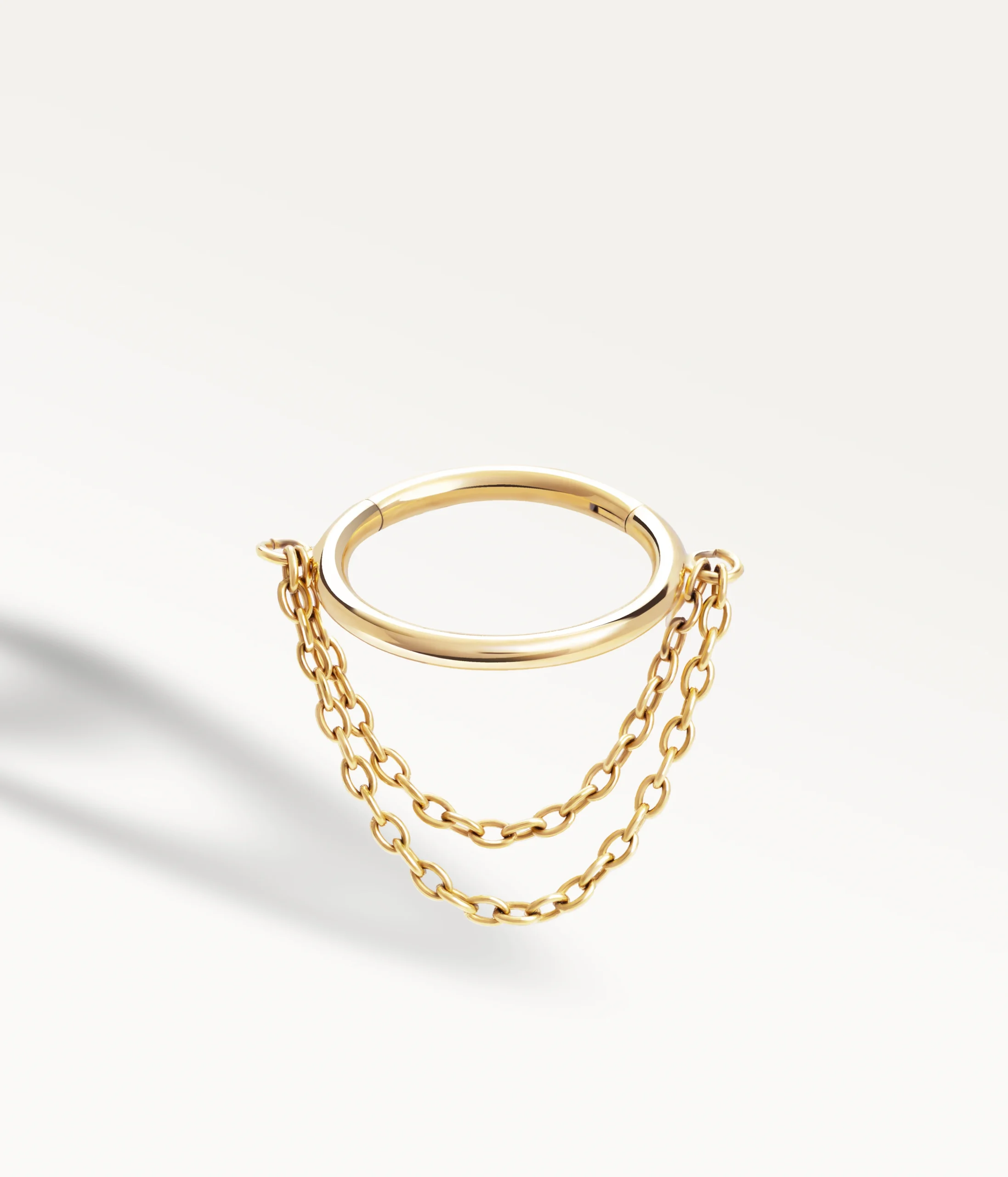 Piercing conch doré orné de deux chaînes délicates reliées à l’anneau