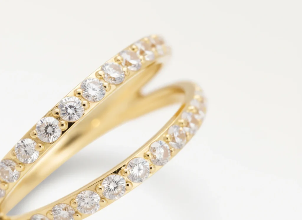 Piercing double anneau doré orné de strass étincelants, vue en gros plan détaillée