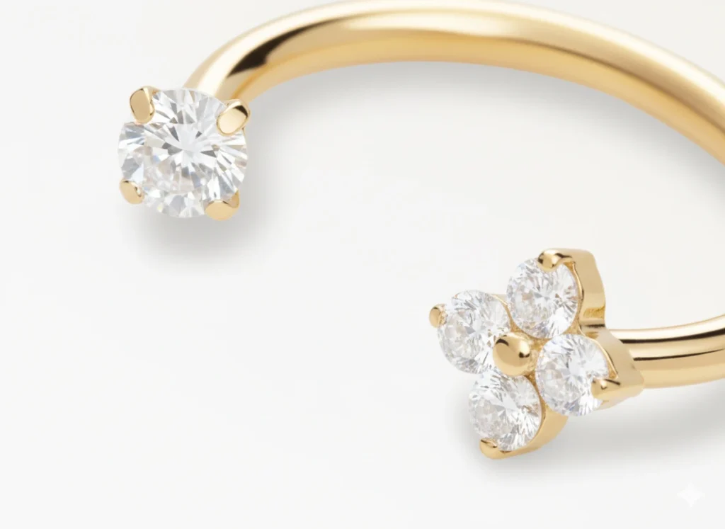 Piercing fer à cheval doré orné d’une fleur sertie de zircons, vue en gros plan élégante