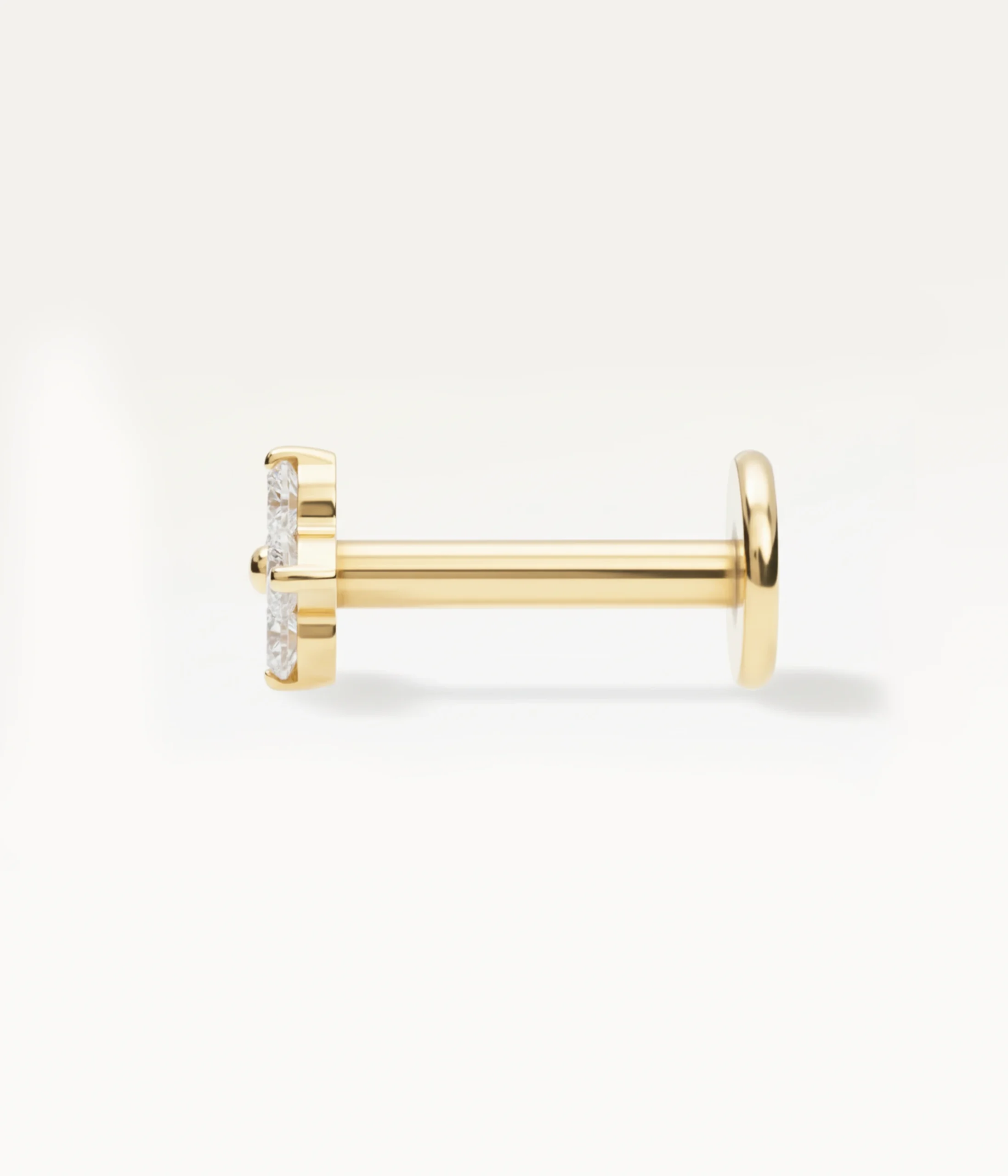 Piercing trèfle doré vu de profil, bijou d’oreille délicat à motif floral brillant