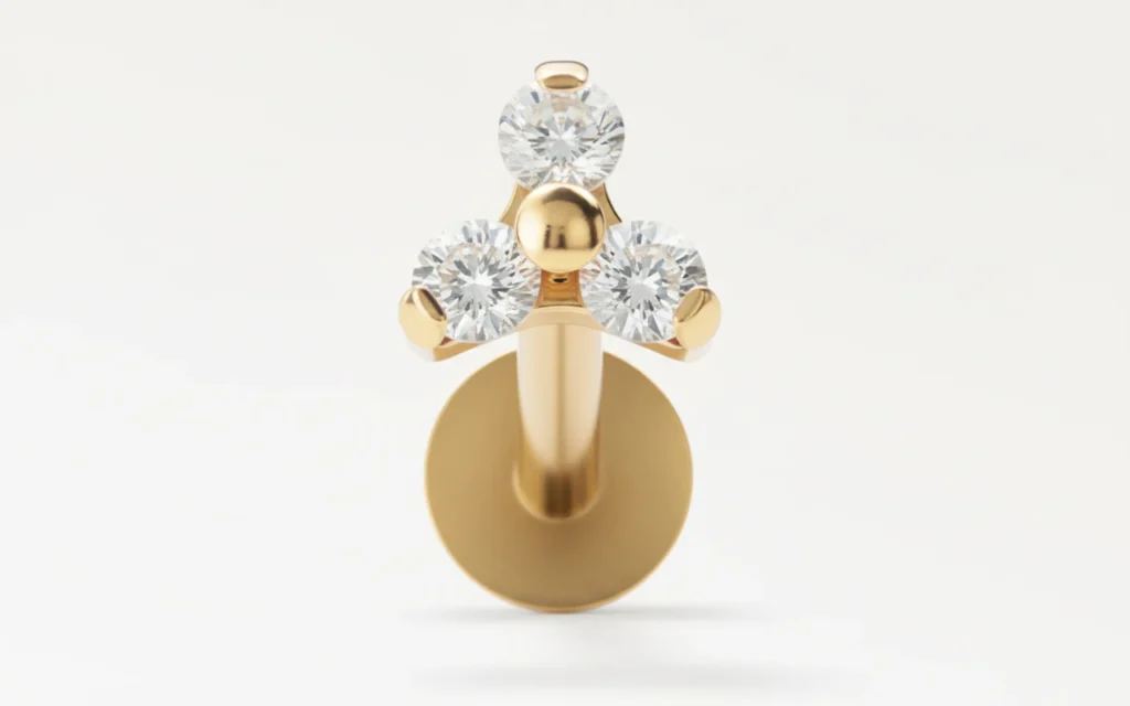 Piercing triangle doré serti de zircons étincelants, vue en gros plan détaillée