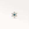 Vue de face détaillée d'un bijou de piercing doré en forme de marguerite avec un diamant bleu au centre et des pétales brillants.